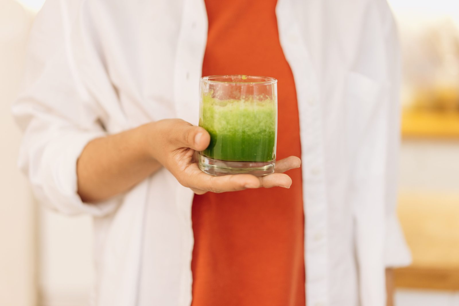 Person holding a fresh green smoothie, photo credit Mikhail Nilov via Pexels